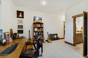 Office area featuring light colored carpet and baseboards