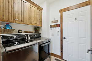 Washroom with washing machine and clothes dryer and cabinet space