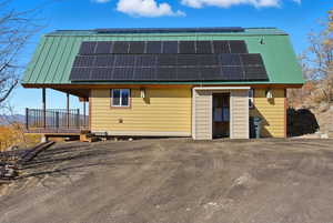 View of front of property featuring a gambrel roof, roof mounted solar panels, and a metal roof