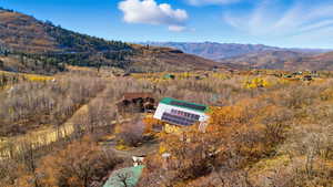 Aerial view of property and surrounding area featuring a mountain backdrop