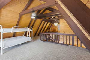 Unfurnished bedroom featuring wood walls, wooden ceiling, and carpet