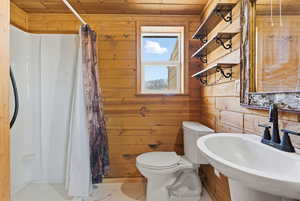 Full bathroom featuring wood walls, a shower stall, tile patterned floors, and wooden ceiling