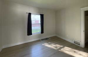 Spare room with baseboards and wood finished floors