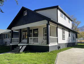 View of front facade with covered porch and a front yard
