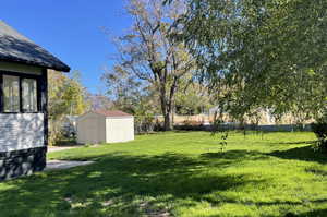 View of grassy yard featuring a shed