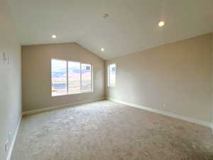 Owner's suite with vaulted ceiling, light colored carpet, and recessed lighting