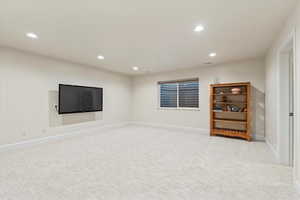 Basement featuring recessed lighting and light colored carpet