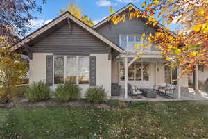 Back of house featuring a yard, a patio, stucco siding, and outdoor lounge area