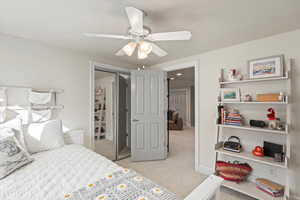 Bedroom featuring light carpet, ceiling fan, and a closet