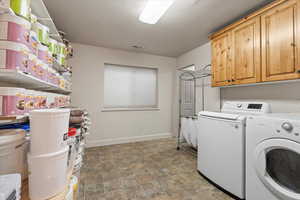 Laundry area featuring washing machine and dryer and stone finish floors