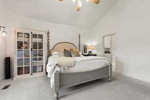 Bedroom featuring high vaulted ceiling, light colored carpet, a ceiling fan, and washer / clothes dryer