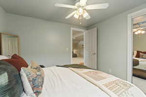 Carpeted bedroom featuring ceiling fan