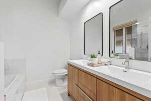 Bathroom featuring double vanity, light tile patterned floors, a relaxing tiled tub, and a stall shower