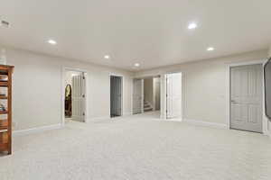 Unfurnished bedroom with recessed lighting and light carpet