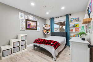 Bedroom with light wood-style floors and recessed lighting