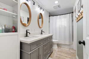 Full bath featuring double vanity and shower / tub combo