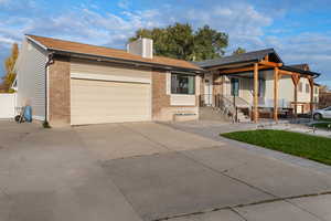 Single story home featuring concrete driveway, brick siding, and a chimney