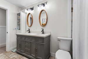 Full bath featuring double vanity and curtained shower