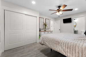 Bedroom featuring light wood-style floors, a closet, recessed lighting, and ceiling fan