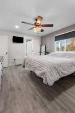Bedroom featuring light wood-style floors, a ceiling fan, and recessed lighting