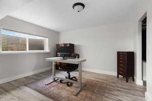 Office area with baseboards and light wood-style flooring