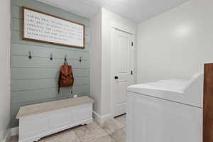Mudroom featuring a textured ceiling and light tile patterned floors