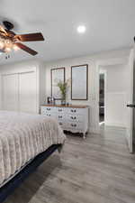 Bedroom featuring light wood-type flooring, recessed lighting, a ceiling fan, and a closet