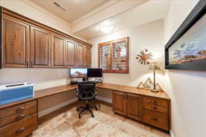 Office with built in study area, custom see-through fireplace, ornamental molding, and light tile flooring