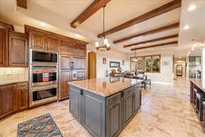 Kitchen featuring recessed lighting, light stone counters, pendant lighting, built in appliances, and backsplash