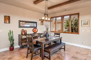Dining room featuring beamed ceiling and light tile patterned flooring
