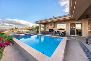 View of swimming pool with a patio, a pool with connected hot tub, and a ceiling fan