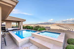 View of swimming pool featuring outdoor lounge area, an in-ground hot tub, a patio, a mountain view, and a fenced backyard