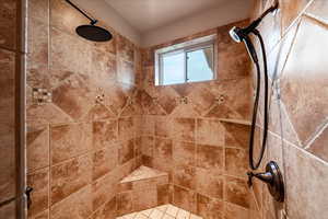 Primary bathroom featuring a tile shower