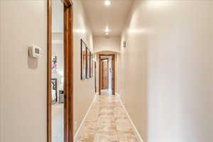 Hallway featuring beautiful walkways and light tile patterned flooring