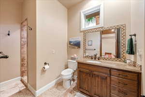 Bathroom with light tile patterned floors, vanity, and walk in shower