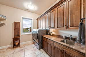 Laundry area with cabinet space, light tile patterned floors, and washing machine and dryer