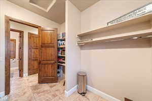 Spacious closet with light tile patterned floors and vaulted ceiling