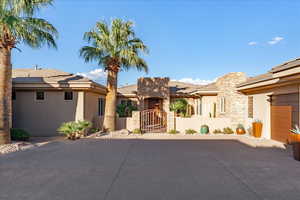 View of front of home with a gate, stucco siding, a fenced front yard, concrete driveway, and stone siding