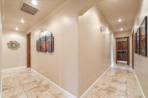Hallway with ornamental molding, recessed lighting, and light tile patterned flooring