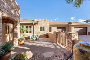 View of patio / terrace with a gate, a garage, and driveway