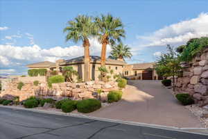 View of front of house with stucco siding, concrete driveway, and an attached garage