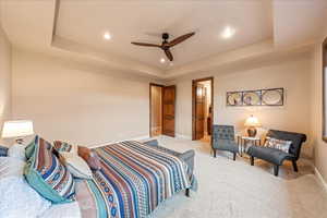 Guest Bedroom featuring a tray ceiling, carpet flooring, ceiling fan, recessed lighting, and connected bathroom