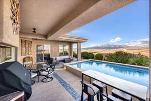 View of swimming pool with area for grilling, outdoor dining space, an outdoor living space, a patio, and ceiling fan