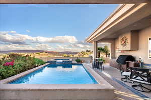 View of swimming pool featuring a patio, area for grilling, and a pool with connected hot tub