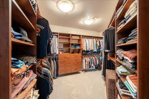 Primary Walk-in closet with light carpet
