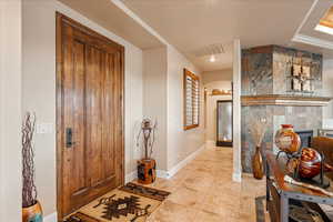 Entrance foyer with a tiled fireplace and light tile patterned floors