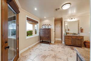Primary Bathroom featuring vanity, ornamental molding, light tile patterned floors, and recessed lighting