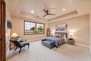 Guest Bedroom featuring a tray ceiling, light colored carpet, recessed lighting, and a ceiling fan