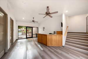 Reception at the club house with vaulted ceiling, recessed lighting, a ceiling fan, and stairway