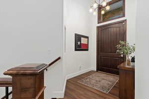 Entrance foyer featuring dark wood finished floors and a chandelier